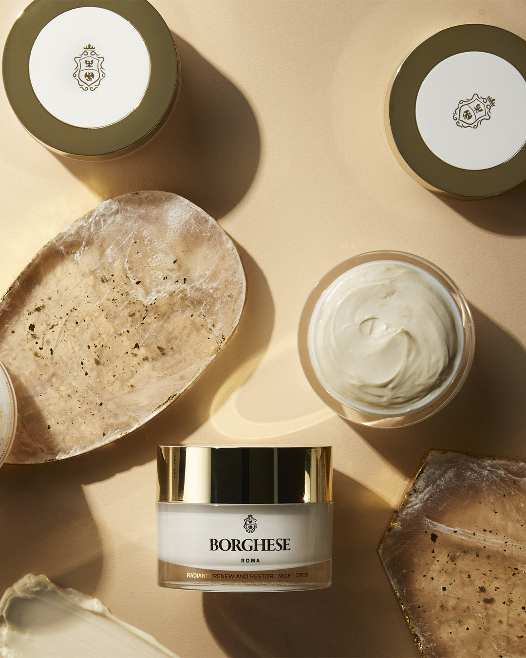Lifestyle shot of multiple jars of the Radiante Renew and Restore Night Creme, reflecting this elegant, hydrating creme
