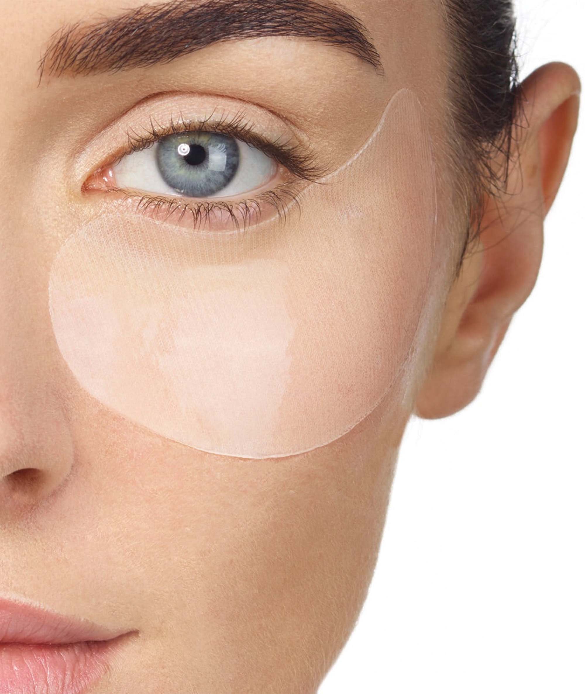 Model using our Restorative Eye Sheet Masks under eyes to provide a more youthful look