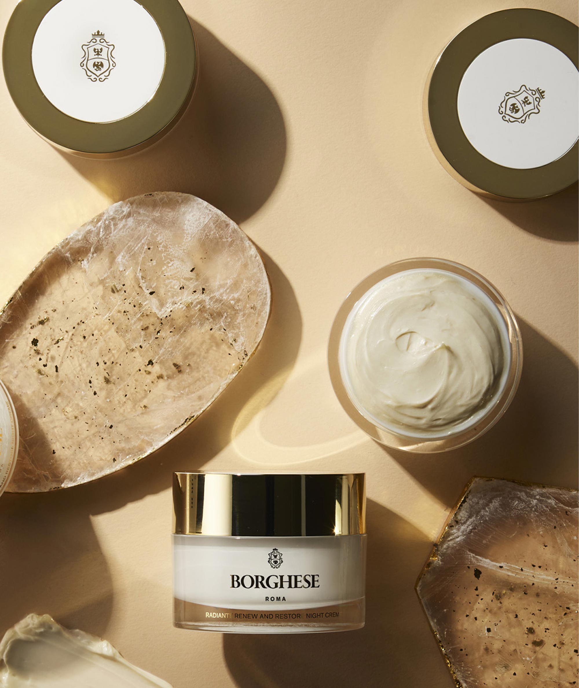 Lifestyle shot of multiple jars of the Radiante Renew and Restore Night Creme, reflecting this elegant, hydrating creme.